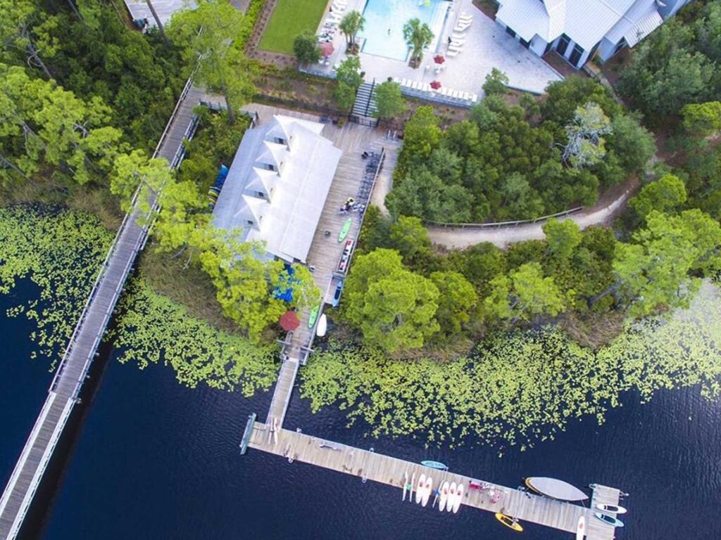 Aerial view of boat house club, pool, building, dock, kayaks and paddleboards