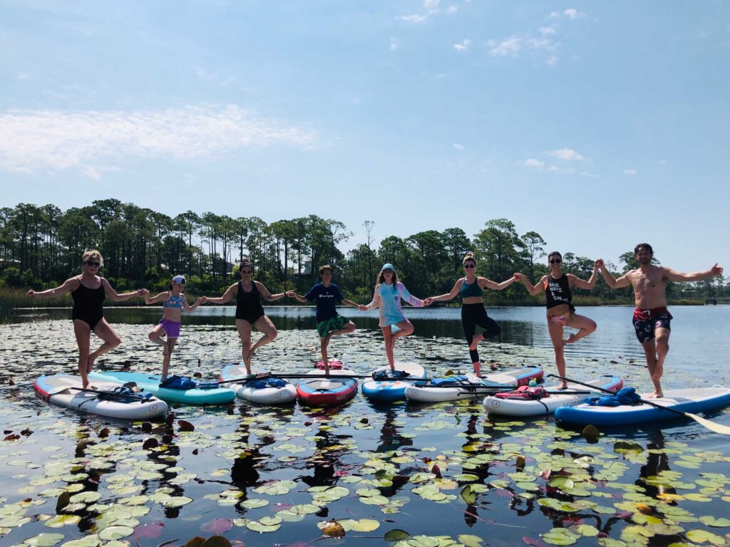 Group of people on paddleboards holding hands